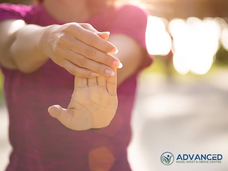 Young fitness woman runner stretching hand before run in the park