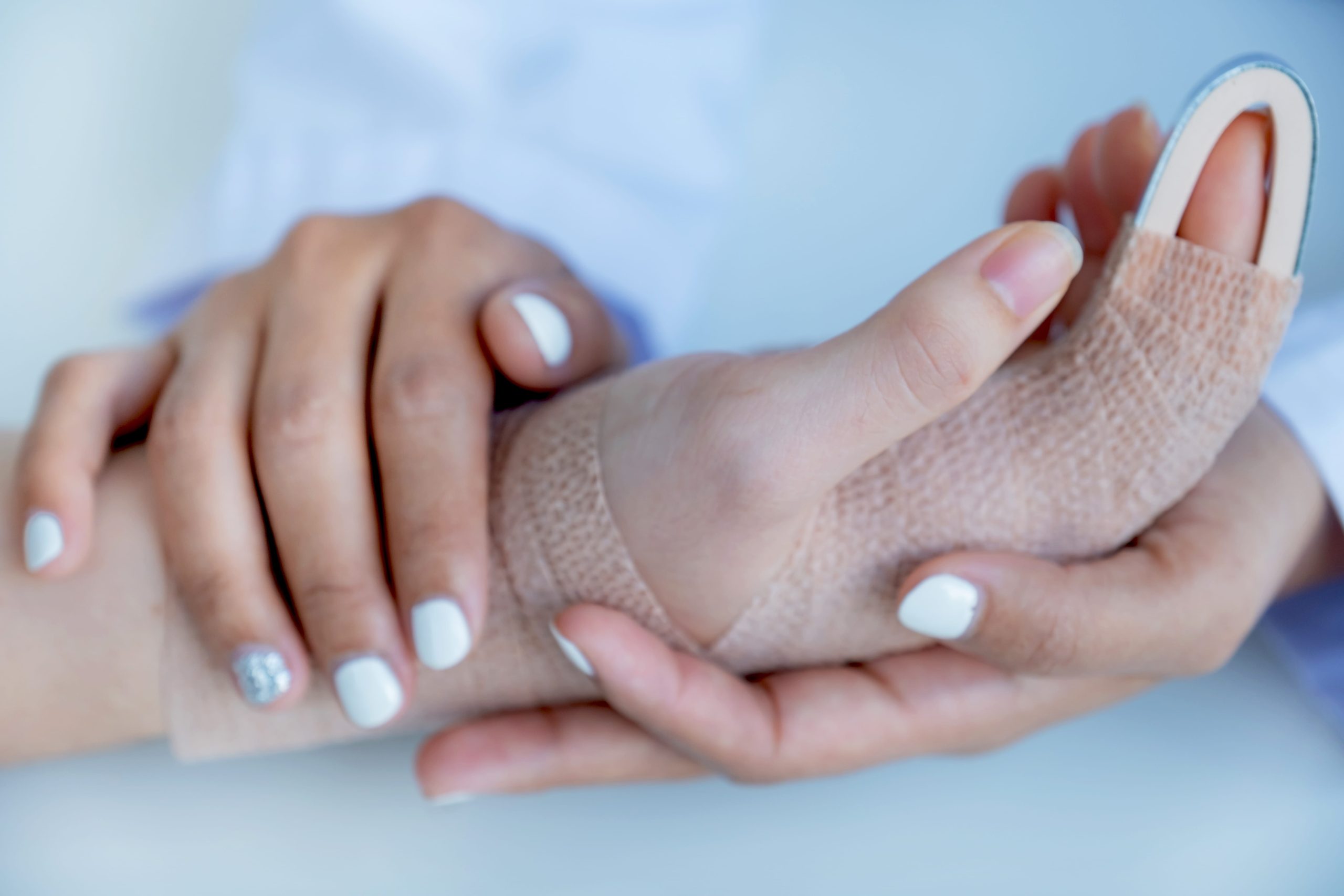 A woman receiving care as her arm is immobilized in a splint, showcasing a soft cast and gentle support.